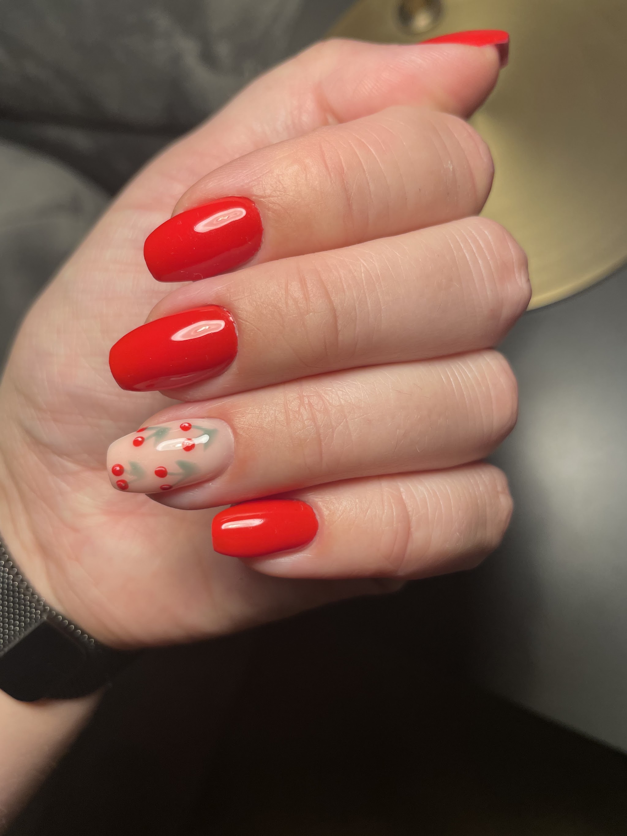 Glanzend rode nagels met één nude nagel met kersjes