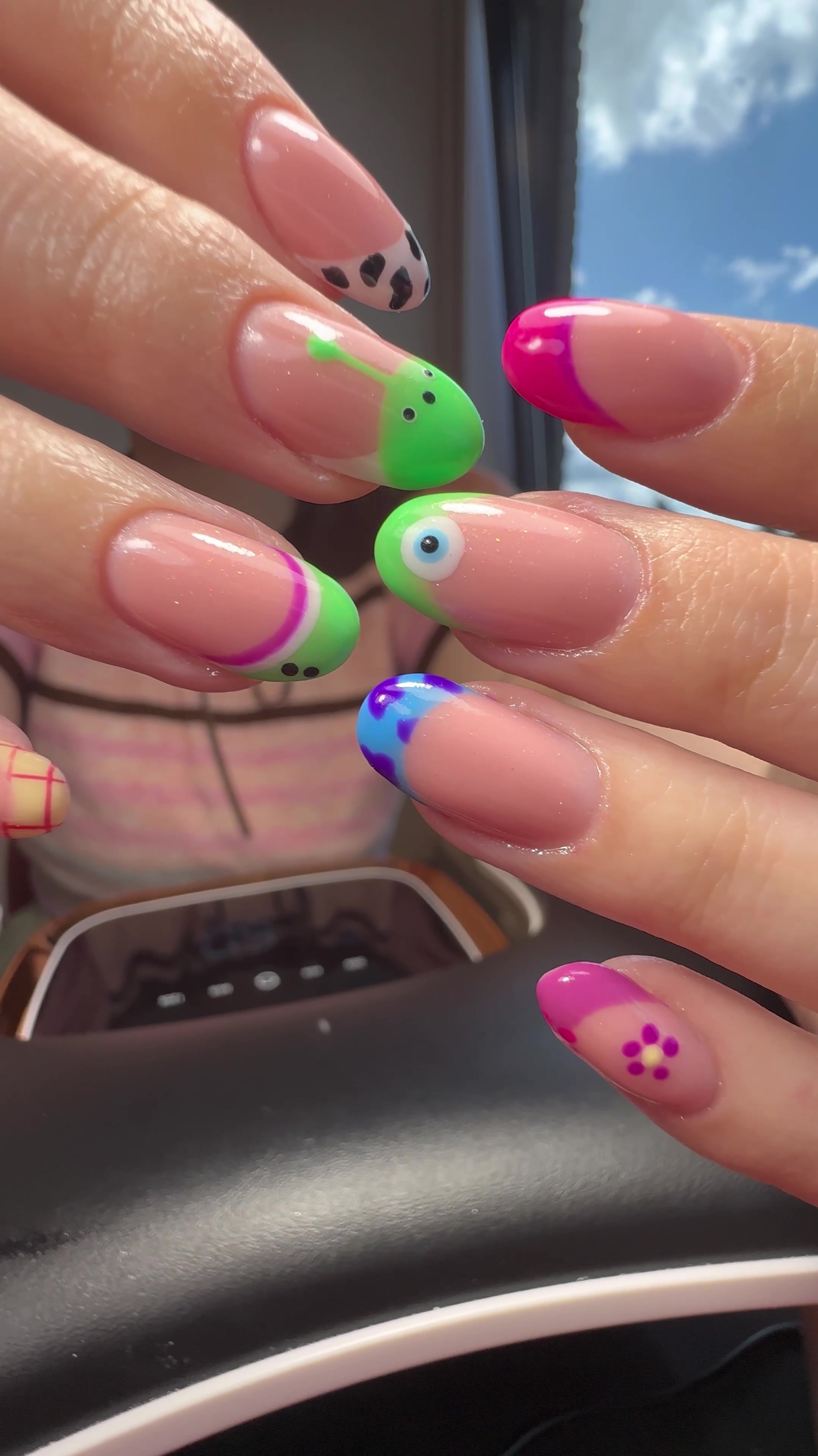Nail art van Valeriia: roze nagels met groene, blauwe en roze tips, een koeienprint en een bloemetje